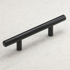 a black cabinet handle on a white surface