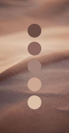 three circles are arranged in the shape of a line on top of a sand dune