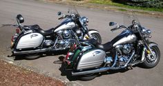 two motorcycles are parked on the side of the road