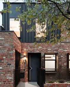 an entrance to a brick building with black iron railings and doors on either side