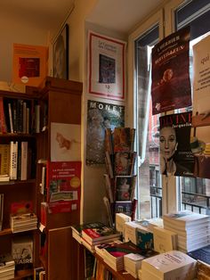 the books are stacked on top of each other in front of a book shelf filled with books