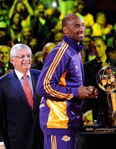 two men standing next to each other near a trophy