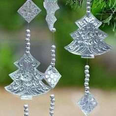 an ornament hanging from a tree with beads on it's sides and another decoration in the background