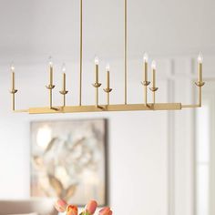 a chandelier with candles hanging from it's sides in a dining room