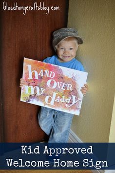 a young boy holding a sign that says kid approved welcome home sign