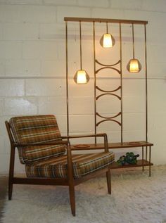 a chair and ottoman in front of a brick wall with three lights on it's sides