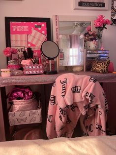 a vanity with pink and black accessories on it, including a robe that says i love you