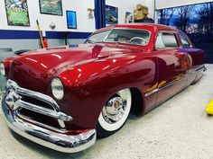 an old red car parked in a garage