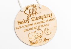 a wooden hanging ornament that says, she's baby sleeping please do not bring the doodles at the door thank you