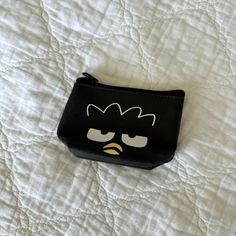 an angry bird coin purse on a white quilted bed with the word angry birds printed on it