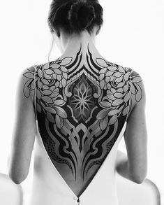 the back of a woman's body with tattoos on it