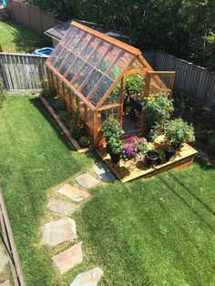 a small greenhouse in the middle of a yard