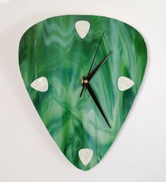 a green clock with white hearts on it