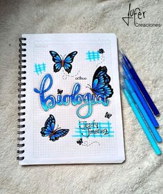 a notebook with some blue butterflies on it and two pencils next to the book