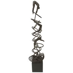 a metal sculpture on top of a black square base with wires coming out of it