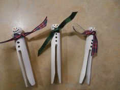 three white toothbrushes with snowmen on them tied to ribbons and sitting next to each other