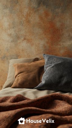 a bed topped with lots of pillows next to a wall covered in rusted paper