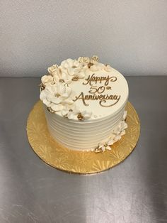 a white and gold wedding cake sitting on top of a table