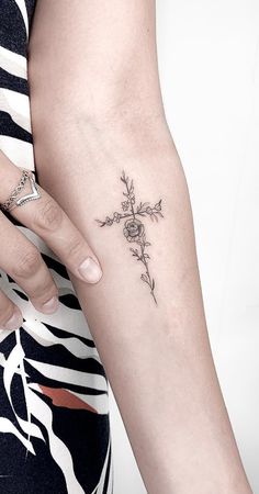 a woman with a cross tattoo on her arm