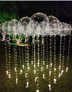 a group of white birds standing on top of a lush green field covered in lights