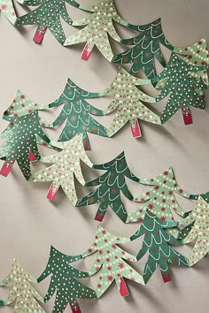 paper cut christmas trees are displayed on the wall