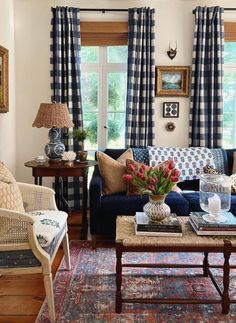 a living room with blue couches and plaid drapes on the windowsills