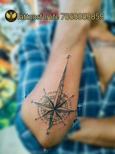 a man's arm with a tattoo on it and a compass in the middle