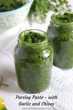 two jars filled with green food sitting on top of a table