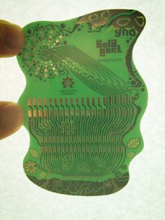 a person holding up a green printed piece of paper with an intricate design on it