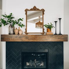 a living room with a fireplace, mirror and potted plants on the mantel