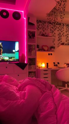 a bedroom with pink lights and a television