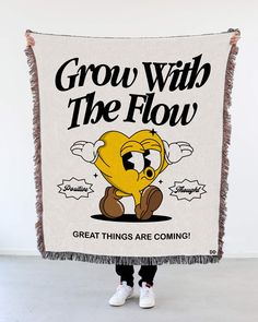 a person holding up a blanket that says grow with the flow