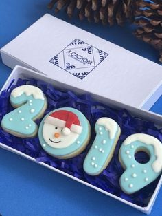 decorated cookies in the shape of numbers and santa's hat are sitting in a box