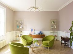 a living room with two green chairs and a coffee table in the middle of it