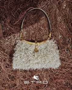 a handbag is laying on the ground covered in red and white yarn, with an embellishment