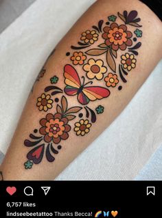 a woman's leg with flowers and butterflies on it