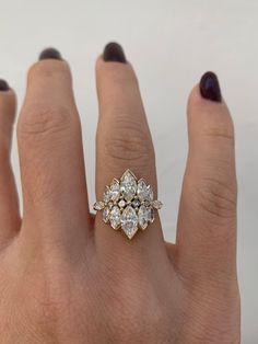 a woman's hand with a diamond ring on top of her finger and two other rings in the middle