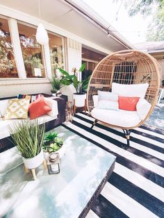 a living room filled with lots of furniture next to a patio covered in potted plants