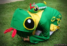 a green and yellow costume laying on top of a lush green grass covered park area