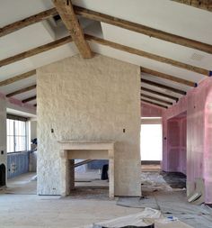 an image of a fireplace in the middle of a room that is being built with wood beams