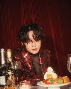 a person sitting at a table with food and wine