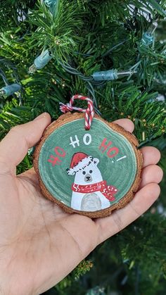 a hand holding a christmas ornament with a dog on it's face