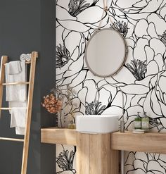 the bathroom is decorated in black and white with flowers on the wall next to the sink