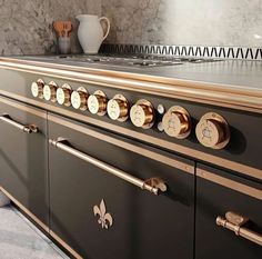 an old fashioned stove with brass knobs in a home kitchen, next to a coffee pot on the counter