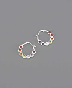 Embrace the harmony and balance of nature with these sterling silver chakra gemstone hoop earrings. Chakra gemstone earrings Made of sterling silver Measures about 0.9" wide Genuine gemstones: Garnet, Carnelian, Citrine, Peridot, Blue Topaz, Iolite, and Amethyst Chakra Stones and Association Amethyst: Crown Chakra Iolite: Third Eye Chakra Blue Topaz: Throat Chakra Peridot: Heart Chakra Citrine: Solar Plexus Chakra Carnelian: Sacral Chakra Garnet: Root Chakra Silver Small Hoop Earrings With Gemstone, Silver Gemstone Hoop Earrings, Sterling Silver Gemstone Hoop Earrings, Sterling Silver Birthstone Hoop Earrings, Silver Gemstone Small Hoop Earrings, Rainbow Colored Round Sterling Silver Jewelry, Rainbow Round Sterling Silver Jewelry, Rainbow Sterling Silver Round Jewelry, Chakra Earrings