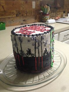 a decorated cake sitting on top of a glass plate in a kitchen next to a counter