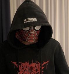 a person wearing a black hoodie with a spiderman face on it