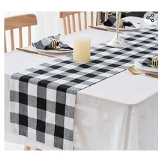 a black and white checkered table runner on a dining room table with two candles