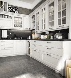 a large kitchen with white cabinets and black counter tops, along with gray flooring