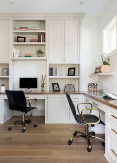 a home office with white cabinets and black chair in the center, built - in bookshelves